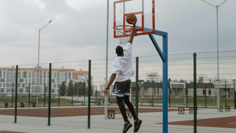 Homme qui fait un dunk dans un city